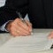 Landrat Joachim Arnold (l.) und Notar Günter Lamotte unterzeichnen den Gesellschaftsvertrag der Breitbandbeteiligungsgesellschaft Wetteraukreis.