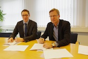 Komnexx-Geschäftsführer Silas Bittmann (links) und Bürgermeister Otto Steinkamp unterzeichnen den Pachtvertrag für das Glasfasernetz der Gemeindewerke Wallenhorst.