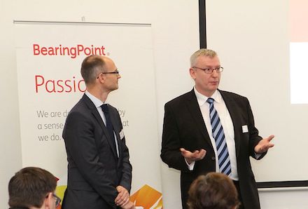 Jon Abele von BearingPoint (links) und Christian Korff von Cisco begrüßen die Finalisten des 15. E-Government-Wettbewerbs in Berlin.