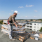 Heizungsbaumeister Lars Ost prüft auf dem Dach die gerade angelieferten Bauteile für die Solaranlage.