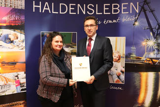 Staatssekretär Thomas Wünsch übergibt der zweiten stellvertretenden Bürgermeisterin, Carola Aust, den Förderbescheid für ein Digitalisierungszentrum in Haldensleben.