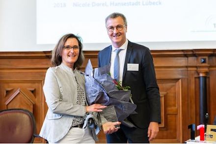 Nicole Dorel, Pressesprecherin der Hansestadt Lübeck, erhält von Ernst Bürger, BMI, den 115-Preis für Presse- und Öffentlichkeitsarbeit.
