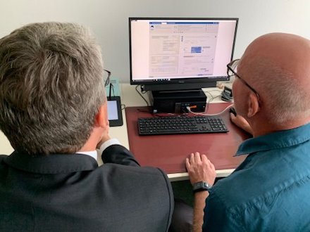 Ein Mitarbeiter der Verwaltung Nidderau zeigt Hessen-CIO Patrick Burghardt, wie ein Ausweis komplett digital beantragt werden kann.