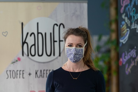 Vanessa König, eine der Inhaberinnen vom kabuff Stoffladen & Café und Mitiniatorin des Jenaer-Projektes, mit einem Modell der Mundmasken.