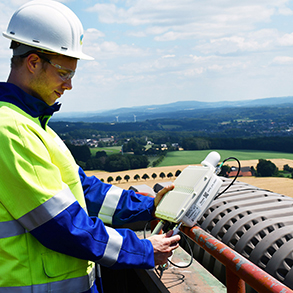 SWTE Netz-Mitarbeiter Felix Schwerter nimmt eines der Gateways für das neue LoRaWAN-Netz auf dem Dach des Kesselhauses des Kraftwerks Ibbenbüren in Augenschein. 