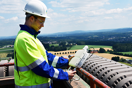 SWTE Netz-Mitarbeiter Felix Schwerter nimmt eines der Gateways für das neue LoRaWAN-Netz auf dem Dach des Kesselhauses des Kraftwerks Ibbenbüren in Augenschein. 