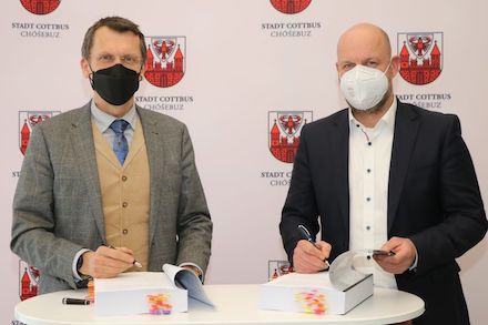 Oberbürgermeister Holger Kelch (l.) und DIKOM-Verbandsvorsteher Oliver Bölke besiegeln die Zusammenarbeit.