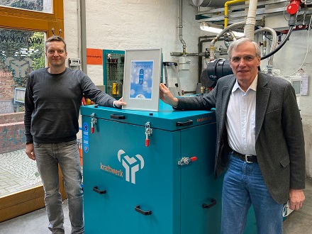 Claus-Heinrich Stahl (rechts) und Markus Henning vor dem mit dem für Blaue Energie zertifizierten BHKW.