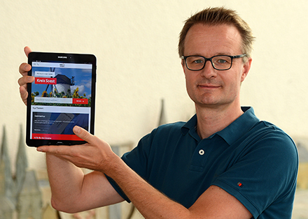 Projektleiter Mathias Keller zeigt auf einem Tablet die Startseite der überarbeiteten Homepage kreis-soest.de.
