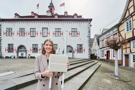 City-Managerin Karin Wessel mit der LoRaWAN-Funkantenne vor dem historischen Rathaus in Linz am Rhein. 