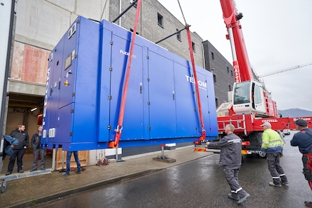 Mithilfe eines Krans wird das acht Tonnen schwere BHKW in das Technikgebäude der evm manövriert.