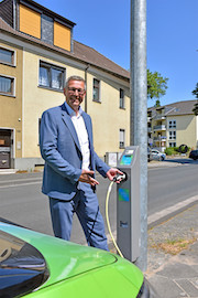 Stadtwerke-Geschäftsführer Frank Thiel testet den Ladepunkt am Laternenmast an der Ümminger Straße in Bochum.