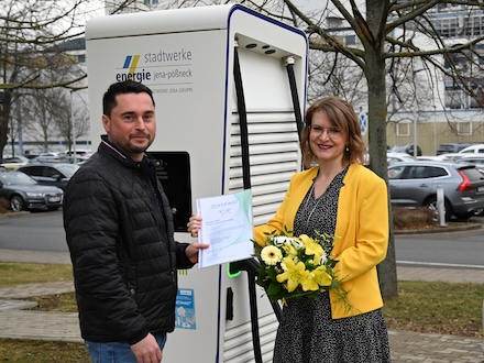 Djamila Neutert, Teamleiterin Energiedienstleistungen bei den Stadtwerken Energie überreicht das Zertifikat an Dennis Beyermann, Thüringens ersten kommunalen Elektromobilitätsmanager.
