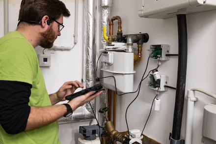 Ein Mitarbeiter der Smart City Solutions GmbH installiert die Sensoren an Gas- und Wasserzählern in einer Hagener Kita.